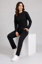 Woman wearing plain black tracksuit seated
