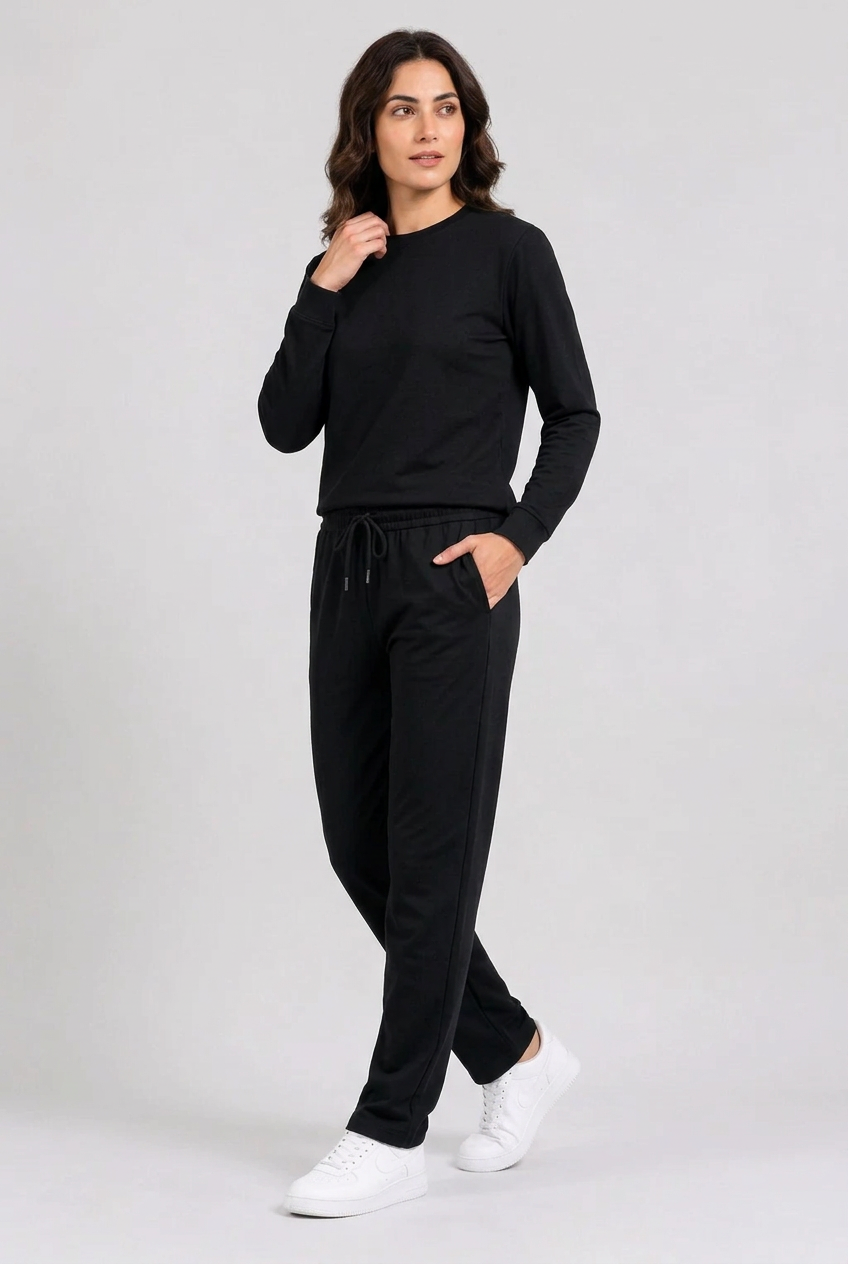 Woman wearing plain black tracksuit walking pose